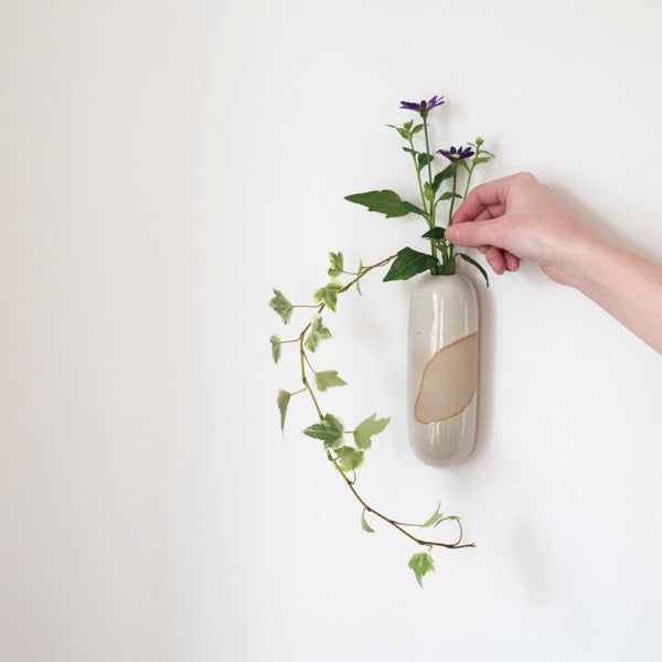 Ivory Tawara hanging flower vase displayed with greenery
